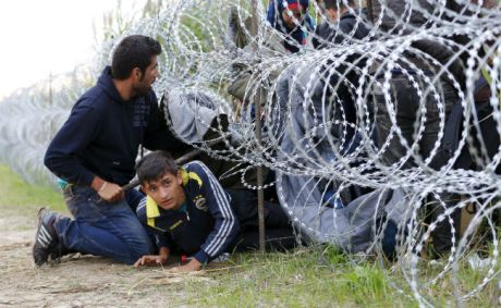 Syrian migrants breaking through razor-wire fencing Hungary/Croatia border